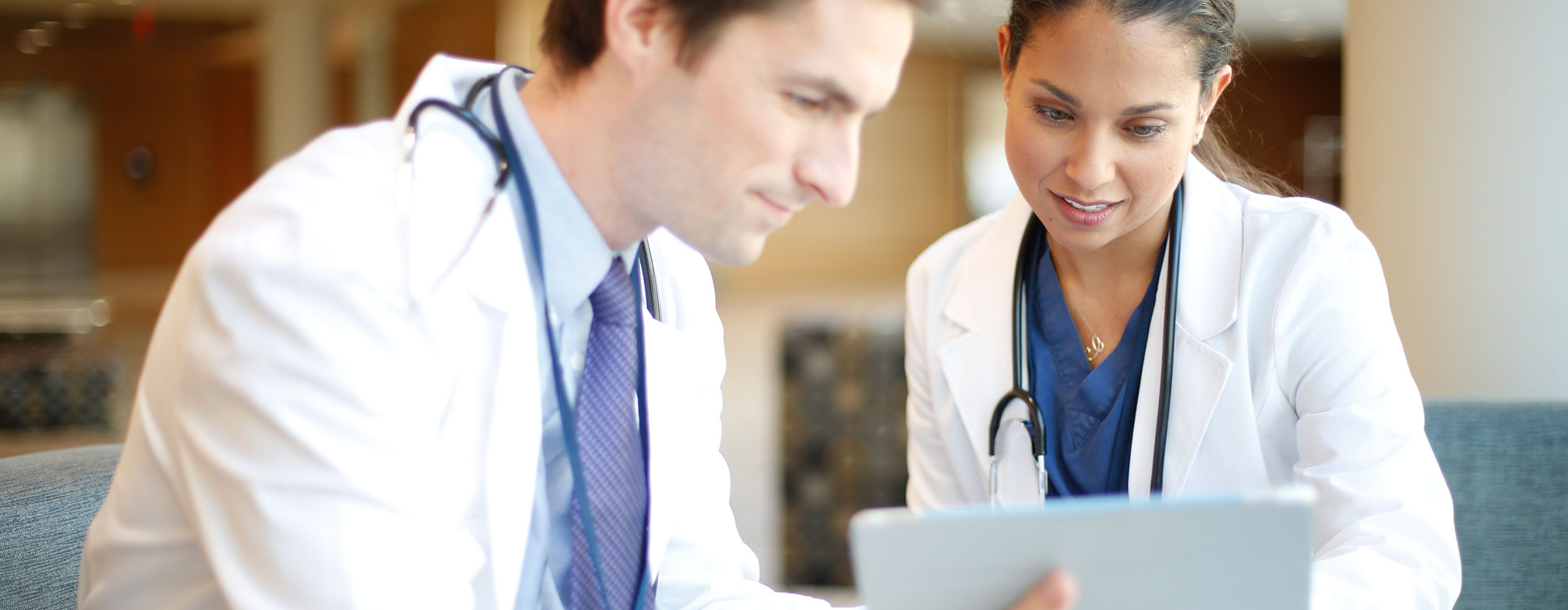 Two physicians looking at a tablet and discussing. 